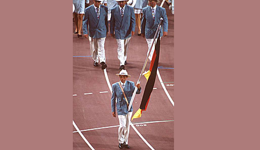 Barcelona 1992: Manfred Klein, Ruder-Olympiasieger von Seoul, trägt die Fahne des wiedervereinten Deutschlands