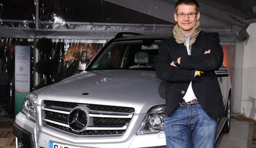 Wojtek Czyz, vierfacher Goldmedaillen-Gewinner der paralympischen Spiele, posiert vor einem Wagen der Mercedes-Benz-Flotte