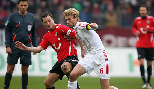 Hannover - Leverkusen 1:0: Leverkusens Rolfes (r.) setzt sich gegen Bruggink durch. Schiri Kinhöfer beobachtet das Ganze