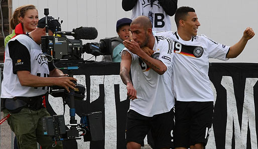 Ashkan Dejagah (l.) traf zum 2:0 für Deutschland und jubelt mit Änis Ben-Hatira und dem Fernsehpublikum