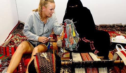 Nachhilfe für Caroline Wozniacki: Dänemarks Tennis-Starlet übt sich im Rahmen des WTA-Turniers in Doha in arabischer Webkunst