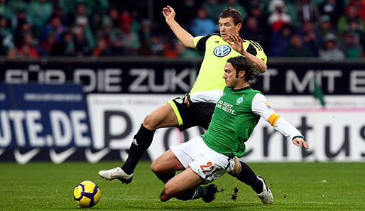 Werder Bremen - VfL Wolfsburg 2:2: Torsten Frings (r.) feierte nach Verletzungspause sein Comeback und grätsch hier gegen Edin Dzeko