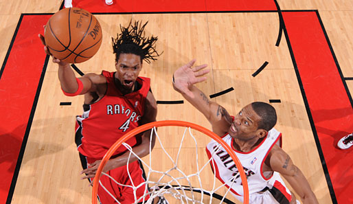 NBA-All-Star Chris Bosh (l.) von den Toronto Raptors lässt beim Dunk die Rastas wirbeln - und Marcus Camby keine Chance