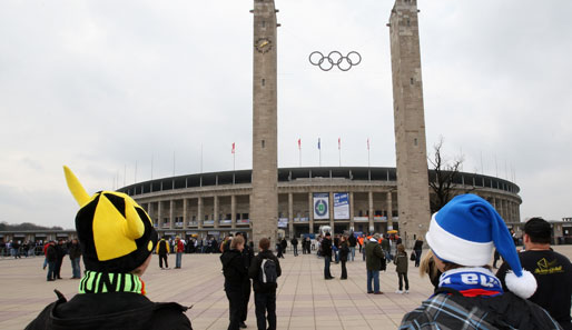 Hertha BSC - Borussia Dortmund 0:0: Zwei junge Fans laufen gen Olympiastadion. Die Hertha geht mit Zipfelmütze ins Rennen, die Borussia setzt auf den Wikinger-Helm