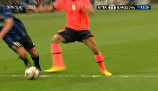 Alves setzt seinen rechten Fuß vor den Ball und Sneijder kommt von hinten