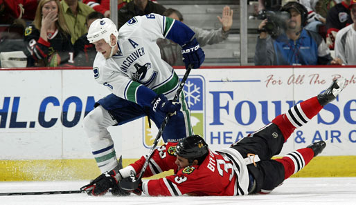"Sliding Tackle" mal anders: Dustin Byfuglien (r.) von den Chicago Blackhawks kämpft im NHL-Match gegen die Vancouver Canucks mit Sami Salo verzweifelt um den Puck