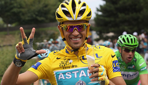 Alberto Conatdor nutzt schon die Schlussetappe der Tour de France zum Feiern: In der linken Hand hält er ein Glas Schampus, mit der rechten zeigt er seinen dritten Tour-Sieg an