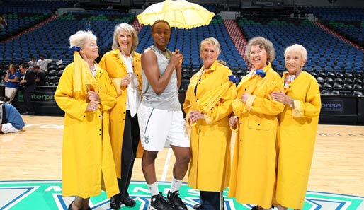 Charde Houston von den Minnesota Lynx posiert vor dem WNBA-Spiel gegen die San Antonio Silver Stars mit den Lynx-Seniortänzerinnen. Mit farblich passendem Schirm