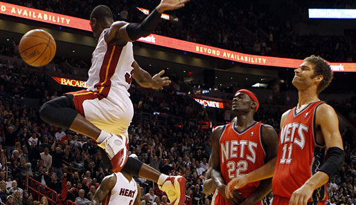 Miami-Guard Dwyane Wade (l.) fliegt in der NBA durch New Jerseys Zone, wie es ihm gefällt. Brook Lopez (r.) und Anthony Morrow (M.) gucken dabei nur dumm aus der Wäsche