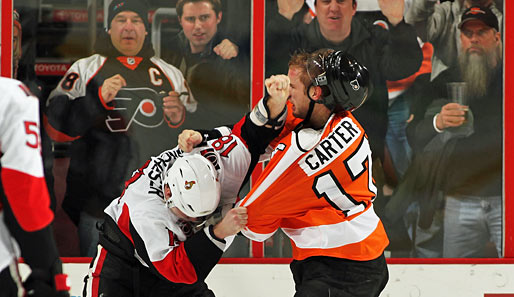 NHL: Flyers-Center Jeff Carter (r.) und Ottawas Jesse Winchester streiten sich um das letzte Marmeladenbrot. Nicht weniger schön: die Gaffer im Hintergrund