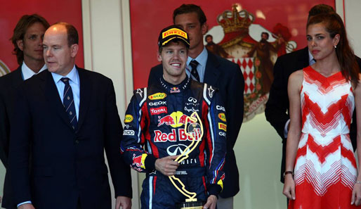 Fühlt sich der Triumphator etwa unwohl? Egal, Hauptsache Vettel (M.) hat die wieder mal skurrile Trophäe in der Hand. Außerdem scheint selbst der Fürst (l.) abgelenkt zu sein