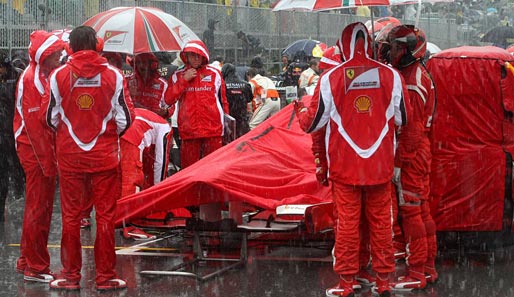 Während der Regenunterbrechung taten die Teams alles, um die Autos halbwegs trocken zu halten. Hier die Ferraristi bei Felipe Massa