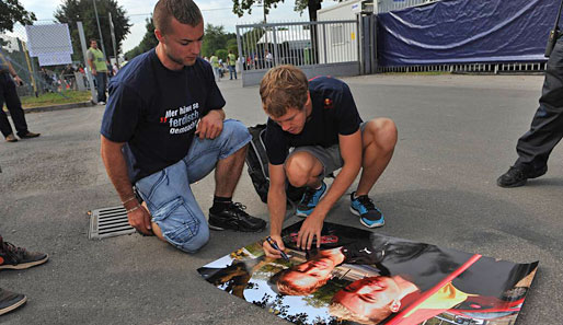 Sebastian Vettel malte zum Wohle seines Fans. Für ein anständiges Autogramm geht der Weltmeister sogar in die Knie