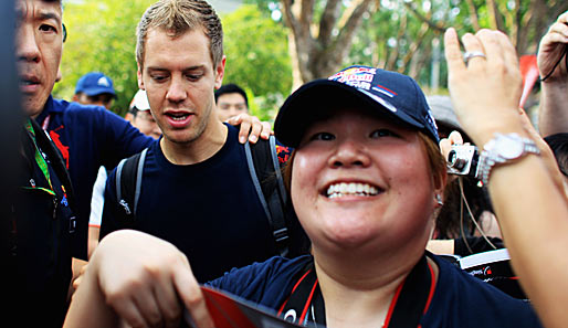 Auch in Singapur ist Sebastian Vettel ein gefragter Mann. Vor dem Freien Training bahnt er sich seinen Weg durch die Fanmassen