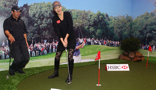 Ein zweites Standbein? Schauspielerin Gong Li versenkt den Putt sicher. Golfprofi und Kurzzeit-Trainer Paul Casey kommt aus dem Staunen nicht mehr raus