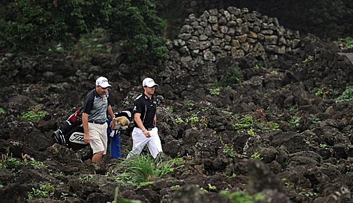 Golfprofi Rory McIlroy wandert mit seinem Caddie während des Trainings in China abseits des Rasens. Bleibt zu hoffen, dass seine Schläge nicht dort landen