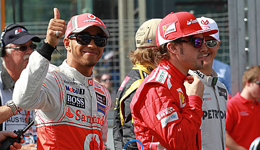 Lewis Hamilton (l.) zeigt sich vor dem Rennen gut gelaunt. Fernando Alonso prüft nochmal den akkuraten Sitz des Rennoveralls.
