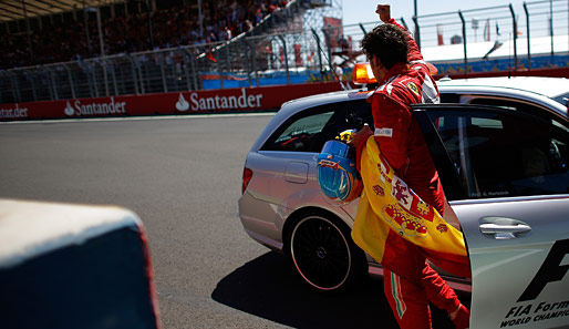 Bei seiner Ehrenrunde blieb Alonso auf der Strecke stehen. Egal: Er besorgte sich eine spanische Flagge, feierte mit den Fans und wurde dann zur Siegerehrung chauffiert