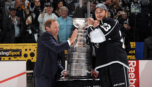 Kapitän Dustin Brown (r.) bekommt von NHL-Commissioner Gary Bettman den Stanley Cup überreicht