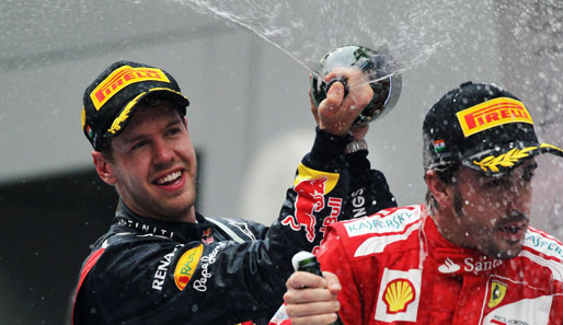 Fünfter Sieg der Saison. Vierter Sieg in Folge: Auch beim Indien-GP macht Sebastian Vettel (l.) Verfolger Fernando Alonso nass