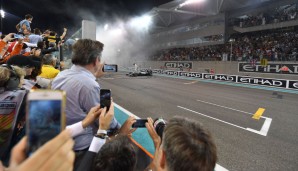 Raus aus dem Auto, die Zielgerade in Gummi-Nebel getaucht, Rosberg feiert auf seinem Mercedes