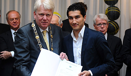 Und da ist das Ding. Bürgermeister Ullrich Sierau präsentiert zusammen mit Nuri Sahin sein Autogramm-Sammel-Album