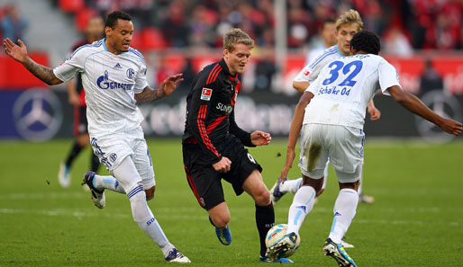 Bayers Andre Schürrle (M.) nimmt es gleich mit zwei Schalkern - Jermaine Jones (l.) und Joel Matip - auf