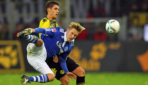 Schalkes Lewis Holtby kämpft gegen Sebastian Kehl akrobatisch um den Ball