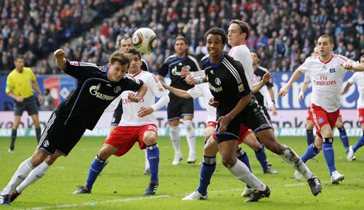 Der Schalker Benedikt Höwedes (l.) klärt einen Eckball vor den heranstürmenden Jansen und Petric