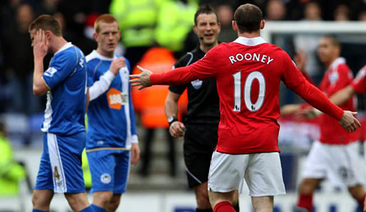 Au Backe! Wigans James McCarthy (l.) reibt sich nach einem Foul von Wayne Rooney die Wange