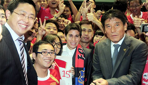 Die Fans von Guangzhou Evergrande empfangen Dario Conca (M.). Links: Präsident Liu Yongzhuo