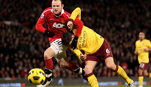 Manchesters Wayne Rooney hat Arsenals Laurent Koscielny fachgerecht im Schwitzkasten