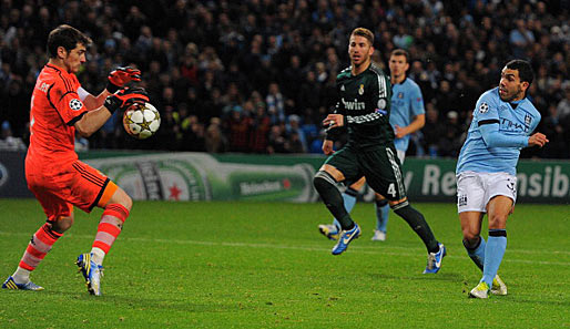 Real Madrids Iker Casillas (l.) pariert einen Schuss von Manchester Citys Carlos Tevez (r.)