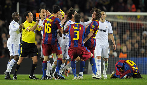 Sergio Ramos (von Pique, Nr. 3, verdeckt) hat Messi (r.) niedergestreckt und greift Puyol ins Gesicht