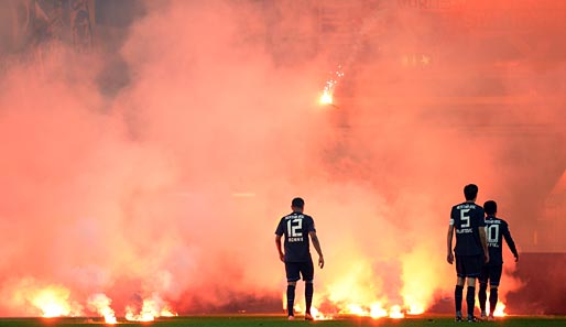 Hertha-Spieler stehen während des Relegationsspiels gegen die Fortuna vor gezündeten Bengalos