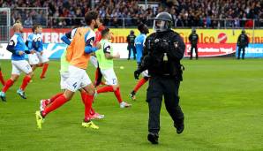 Während des Warmmachens der Teams mussten Sicherheitskräfte anrücken, weil mehrere Kieler Ultras auf den Platz stürmten...