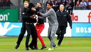 Vor der Partie zwischen Holstein Kiel und dem FC St. Pauli haben vermummte Anhänger der Kieler am gegnerischen Gästeblock eine Fahne geklaut