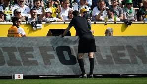 Schiedsrichter Manuel Gräfe schaut sich eine strittige Szene während der Bundesliga-Partie zwischen Gladbach und Dortmund an.