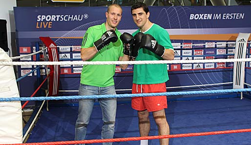 Box-Champ Marco Huck (r.) zeigte Rodelweltmeister David Möller, wie man Boxhandschuhe bedient