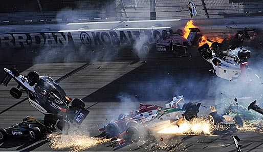 Dan Wheldons Auto mit der Startnummer 77 (l.) wurde bei einem Unfall in die Luft geschleudert