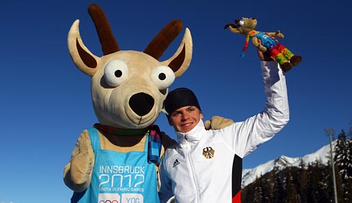Niklas Homberg (r.) feiert zusammen mit Maskottchen Yoggl seine Goldmedaille