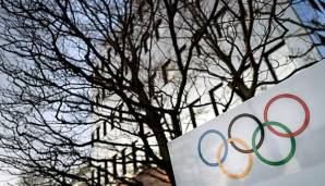 Die Olympischen Ringe im Vordergrund eines Komitee-Hauses der Schweiz