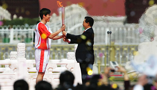 31. März: Der chinesische Staatschef Hu Jintao reicht die Fackel weiter an Liu Xiang, 110-Meter-Hürden-Olympiasieger von Athen 2004