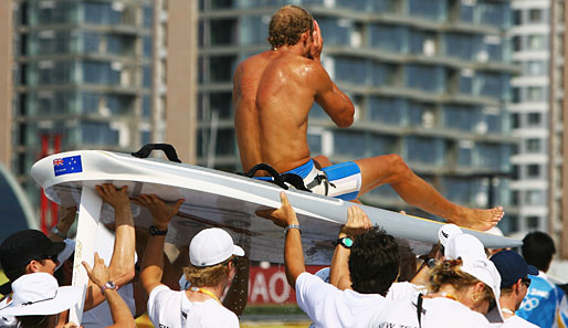 Der Goldmedaillengewinner mit dem Surfbrett RS:X, Tom Ashley, wird von seinem Team auf Händen getragen