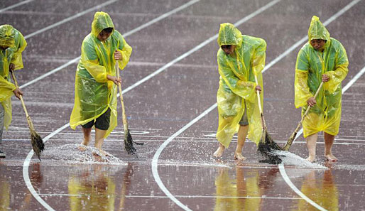 Chinesische Putzkolonne: Die Leichtathletik-Wettbewerbe wurden vom starken Regen beeinträchtigt