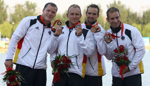 Lutz Altepost, Norman Broeckl, Torsten Eckbrett und Bjoern Goldschmidt freuen sich über ihre Bronzemedaille im Kajak-Vierer über 1000 m