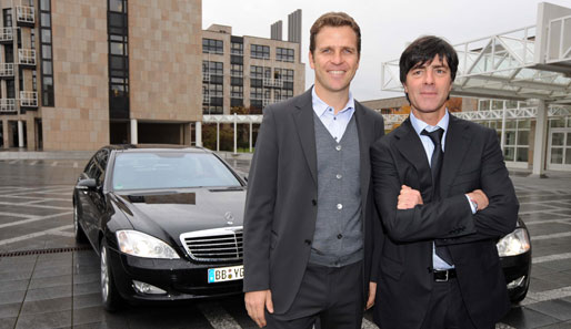 Oliver Bierhoff und Joachim Löw posieren stolz vor ihrem neuen Dienstwagen