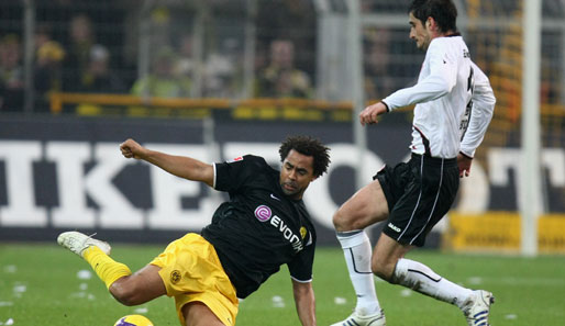 Dortmunds Patrick Owomoyela grätscht Nikos Liberopoulos den Ball vom Fuß