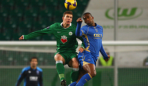 Edin Dzeko im Kopfballduell mit Portsmouths Sylvain Distin (re.)