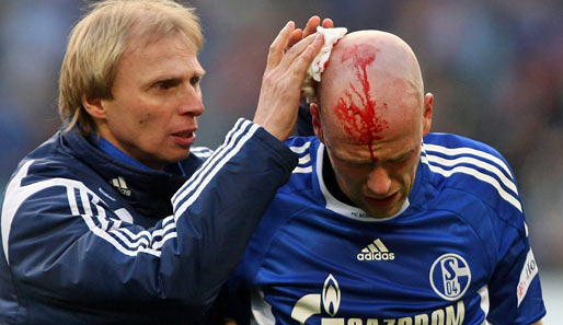 Hannover 96 - Schalke 04: Fabian Ernst muss wegen einer Platzwunde am Kopf von einem Schalker Betreuer behandelt werden